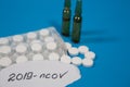 An epidemic of coronavirus infection is taking over the world. Photo of tablets, ampoules and the ncov-2019 inscription in Close-u