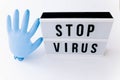 Epidemic and healthcare concept - close up of lightbox with Stop corona virus caution words and protective glove balloon