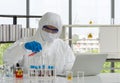 Epidemiological researchers in virus protective clothing mixing chemicals according to formulas obtained from computers