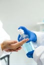 Epidemiological researchers in virus protective clothing washing hands with alcohol gel before beginning the experiment in a