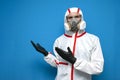 Epidemiologist in a chemical protective suit shows copyspace on a background, man, biologist, scientist, virologist