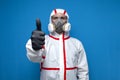 Epidemiologist in a chemical protective suit shows an like sign on a isolated background, man, biologist, scientist, virologist.