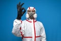 Epidemiologist in a chemical protective suit shows an okay sign on a isolated background, man, biologist, scientist, virologist.