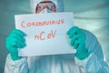 Epidemiologist holding Coronavirus bCoV paper banner in quarantine