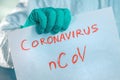 Epidemiologist holding Coronavirus bCoV paper banner in quarantine