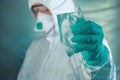 Epidemiologist holding respiratory mask with blood stains