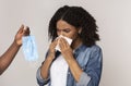 Epidemy Prevention. Male Hand Offering Protective Mask To Sick Black Woman Royalty Free Stock Photo