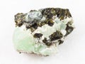 Epidote crystals on prehnite gemstone on white