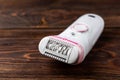 Epilator for woman depilation on dark wooden background