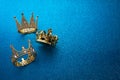 Epiphany Day or Dia de Reyes Magos concept. Three gold crowns on blue sparkling background