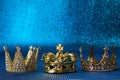 Epiphany Day or Dia de Reyes Magos concept. Three gold crowns on blue sparkling background Royalty Free Stock Photo