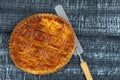 Epiphany Twelfth Night cake french galette des rois made of puff pastry with the charm inside, black wooden background