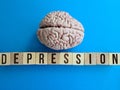 epression is written with wooden cubes on table and human brain