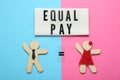 Equal pay concept. Wooden figures of man and woman on color background, flat lay