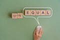 equal rights or gender concept, EQUAL text on wooden cube blocks inside speech bubble with hand using wireless mouse Royalty Free Stock Photo