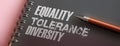 Equality Tolerance Diversity words on page of copybook and pen. Social concept