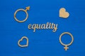 EQUALITY word carved out of plywood. Symbol of gender equality. Blue wooden background