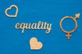 EQUALITY word carved out of plywood. Symbol of gender equality. Blue wooden background