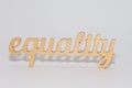 EQUALITY word carved out of plywood. Symbol of gender equality. White background