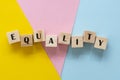 Equality word made withwooden blocks over colorful pink, yellow, blue background, inclusion concept Royalty Free Stock Photo