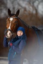 Equestrian country girl and her bay horse are in winter Royalty Free Stock Photo
