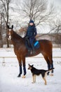 Equestrian country girl riding her bay horse in winter Royalty Free Stock Photo