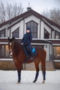 Equestrian country girl riding her bay horse in winter Royalty Free Stock Photo