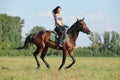 Equestrian girl with sportive horse runs gallop in nature background