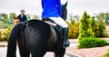 Black dressage horse and rider in uniform performing jump at show jumping competition. Royalty Free Stock Photo