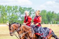 Equestrian sport dressage, passage - two young girls in beautiful clothes sit on a horse