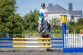 Equestrian sport. Young girl jumping over obstacle Royalty Free Stock Photo