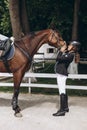 Equestrian sport - a young girl is standing near horse