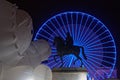 Equestrian statue and big blue wheel with a white huge character