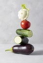 Equilibrium floating fresh vegetables on gray background. Vertical format