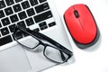 Black glasses on a laptop, red mouse isolated on a white background Royalty Free Stock Photo