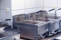Equipment for deep-frying dishes. Industrial fryers in a restaurant. Stainless steel deep fryers