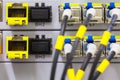 Equipment of radio base station close-up, blue and yellow optic patch cords.