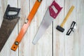 The equipment for woodworking is organized neatly on the wood floor. Ordered as follows, old saw full of rust, orange magnetic Royalty Free Stock Photo