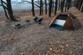 Equipped camp in the forest. Camping tent and portable chairs and aluminum table. Cold autumn day. concept of vacation and outdoor Royalty Free Stock Photo