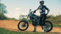 Equipped motorcycler is standing beside the autobike