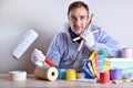 Equipped worker presenting paint products on wood table