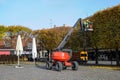 Equipped worker pruning a tree on a crane. Gardening