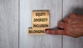 Equity, diversity, inclusion and belonging symbol. Wooden blocks with words `equity, diversity, inclusion, belonging` on beautif