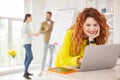 Jolly female employee working with laptop