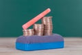 Eraser, dollar coins and a piece of chalk on the blackboard Royalty Free Stock Photo