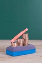 Eraser, dollar coins and a piece of chalk on the blackboard Royalty Free Stock Photo