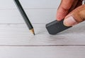 Eraser and error concept, Hand with black eraser and pencil on white table Royalty Free Stock Photo