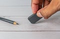 Eraser and error concept, Hand with black eraser and pencil on white table Royalty Free Stock Photo