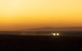 Car`s headlights in the sunset in Erg Chigaga, Morocco.