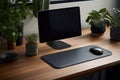 Ergonomic elegant luxury workplace. Modern computer, black leather mousepad and green potted plants on wooden table Royalty Free Stock Photo